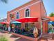 Inviting outdoor patio with red umbrellas for shade at the Bonjour French Cafe at 1240 Northport Dr, Sarasota, FL 34242