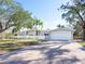 Charming single Gathering home with a brick driveway, luscious mature trees and an attached two car garage at 1240 Northport Dr, Sarasota, FL 34242