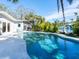 A stunning backyard with a sparkling pool surrounded by lush tropical landscaping and waterfront views at 1240 Northport Dr, Sarasota, FL 34242