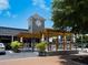 Outdoor dining area with a pergola and hanging lights at a restaurant under clear blue sky at 1240 Northport Dr, Sarasota, FL 34242