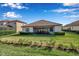 A sunny exterior view of the back of the house, showcasing the lanai and backyard at 13303 Swiftwater Way, Lakewood Ranch, FL 34211