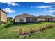 The backyard features a well-maintained lawn, a screened-in lanai, and lush green landscaping at 13303 Swiftwater Way, Lakewood Ranch, FL 34211