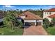 Beautiful home featuring a two-car garage, barrel tile roof and a brick paved drive framed by lush landscaping at 13303 Swiftwater Way, Lakewood Ranch, FL 34211