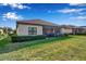 Exterior shot of the back of the house, including the lanai and manicured lawn with landscaping at 13303 Swiftwater Way, Lakewood Ranch, FL 34211