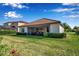 Exterior view of the backyard shows lush green grass, landscaping, and a screened-in lanai at 13303 Swiftwater Way, Lakewood Ranch, FL 34211