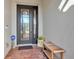 Close-up of front entrance, showcasing a decorative glass panel door and a place to sit at 13303 Swiftwater Way, Lakewood Ranch, FL 34211