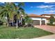 Charming home featuring a two-car garage, barrel tile roof and a brick paved drive framed by lush landscaping at 13303 Swiftwater Way, Lakewood Ranch, FL 34211