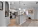 Modern kitchen with stainless steel appliances, a granite countertop bar, and wood floors at 13303 Swiftwater Way, Lakewood Ranch, FL 34211