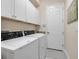 Laundry room with side by side white washer and dryer and white cabinets above at 13303 Swiftwater Way, Lakewood Ranch, FL 34211