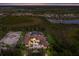 Aerial shot of an estate featuring a tennis court, large lawn, and elegant home design at 16416 Baycross Dr, Lakewood Ranch, FL 34202