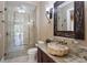 Bathroom with granite countertops, unique stone sink, ornate mirror and glass-enclosed shower at 16416 Baycross Dr, Lakewood Ranch, FL 34202