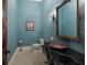 Elegant powder room with copper sink, decorative mirror, and textured blue walls at 16416 Baycross Dr, Lakewood Ranch, FL 34202