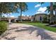 Paver driveway approaching a well-maintained estate with manicured lawns and mature landscaping at 16416 Baycross Dr, Lakewood Ranch, FL 34202