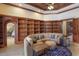 Living room with wood-paneled walls, book shelves, and a large sectional sofa at 16416 Baycross Dr, Lakewood Ranch, FL 34202