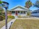 Charming home with a decorative red door, covered porch, and patterned brick walkway at 1687 Arlington St, Sarasota, FL 34239