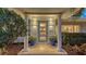 Inviting front entrance featuring a blue glass-panel door, elegant columns, and potted flowers at 1735 Flower Dr, Sarasota, FL 34239