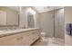 An updated bathroom with double sinks, stone countertops, and a walk-in shower with a glass door at 1919 Irving St, Sarasota, FL 34236