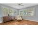 Bright bedroom with hardwood floors, a plush chaise lounge and sunny windows with shutter at 1919 Irving St, Sarasota, FL 34236