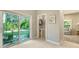 Hallway with tile flooring, lush landscape view and access to a powder room at 1919 Irving St, Sarasota, FL 34236