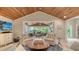 A modern living room with a vaulted wood ceiling, light tile floors and a view of the lanai at 1919 Irving St, Sarasota, FL 34236