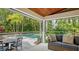 Inviting covered patio with roll down shades, comfortable seating and views of the pool and landscaping at 1919 Irving St, Sarasota, FL 34236