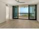 Spacious bedroom with a ceiling fan, wood floors, and a sliding glass door leading to a balcony with a water view at 1932 Harbourside Dr # 244, Longboat Key, FL 34228