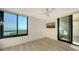 Well-lit bedroom featuring wood floors, a window with a water view, and a sliding glass door to the outside at 1932 Harbourside Dr # 244, Longboat Key, FL 34228