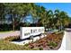 Community entrance sign framed by landscaping and flowering plants, creating a welcoming and upscale impression at 1932 Harbourside Dr # 244, Longboat Key, FL 34228