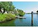 Dock on a calm canal with mature tropical landscaping surrounding the area and boats moored nearby at 1932 Harbourside Dr # 244, Longboat Key, FL 34228