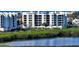 Beautiful white condo building with lush green landscaping and waterfront views at 1932 Harbourside Dr # 244, Longboat Key, FL 34228