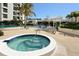 Community hot tub and pool area featuring comfortable seating, palm trees and shade structure at 1932 Harbourside Dr # 244, Longboat Key, FL 34228