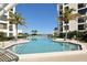 Relaxing community pool area surrounded by swaying palm trees and comfortable lounge chairs at 1932 Harbourside Dr # 244, Longboat Key, FL 34228