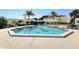 Large community pool surrounded by deck chairs and palm trees on a sunny day at 1932 Harbourside Dr # 244, Longboat Key, FL 34228