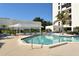 Community pool and patio with shade structure and lounge chairs at 1932 Harbourside Dr # 244, Longboat Key, FL 34228