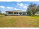 Spacious backyard showcasing lush greenery and partial views of the home's screened-in porch at 19484 Midway Blvd, Port Charlotte, FL 33948