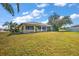 Spacious backyard showcasing lush greenery and partial views of the home's screened-in porch at 19484 Midway Blvd, Port Charlotte, FL 33948