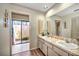 Bathroom featuring double sinks, lots of counter space, and a door leading to an outdoor courtyard at 19484 Midway Blvd, Port Charlotte, FL 33948