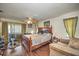 Cozy bedroom with wood flooring, a ceiling fan, and a comfortable seating area near a sunlit window at 19484 Midway Blvd, Port Charlotte, FL 33948