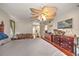 Bedroom featuring a fan, couch, dressers, and view into the bathroom at 19484 Midway Blvd, Port Charlotte, FL 33948