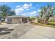 Charming single-story home featuring an attached garage, screened entryway, and mature landscaping at 19484 Midway Blvd, Port Charlotte, FL 33948