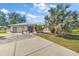 Charming single-story home featuring an attached garage, screened entryway, and mature landscaping at 19484 Midway Blvd, Port Charlotte, FL 33948