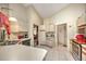 Bright kitchen with white tile floor, featuring stainless steel appliances and breakfast bar at 19484 Midway Blvd, Port Charlotte, FL 33948