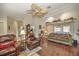 Comfortable living room featuring hardwood floors, ceiling fan, and access to other rooms at 19484 Midway Blvd, Port Charlotte, FL 33948