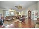 Inviting living room featuring hardwood floors, comfortable seating, and a classic grandfather clock at 19484 Midway Blvd, Port Charlotte, FL 33948