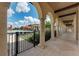 Walkway with a series of pillars overlooking a pool with lounge chairs and umbrellas on a sunny day at 20170 Benissimo Dr, Venice, FL 34293