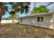 Side view of the home's backyard with lawn and some wood chip landscaping at 22151 Lancaster Ave, Port Charlotte, FL 33952