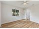 Inviting bedroom with neutral walls, a ceiling fan, wood-look floors, and view to tropical foliage at 22151 Lancaster Ave, Port Charlotte, FL 33952