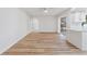 Bright living space with wood-look floors, leading to a modern kitchen with white cabinetry at 22151 Lancaster Ave, Port Charlotte, FL 33952