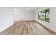 Bright living room featuring stylish wood-look floors, a large window, and fresh paint at 22151 Lancaster Ave, Port Charlotte, FL 33952