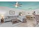 Bright living room featuring a large sectional sofa, a ceiling fan, tile floors, and a dining area with seating for six at 224 17Th St # 224, Bradenton Beach, FL 34217